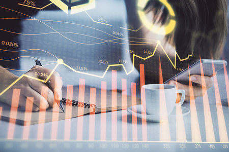 Double exposure of forex graph sketch hologram and woman holding and using a mobile device. Stock market concept.の写真素材