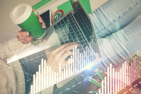 Double exposure of woman hands typing on computer and forex chart hologram drawing. Stock market invest concept.の写真素材