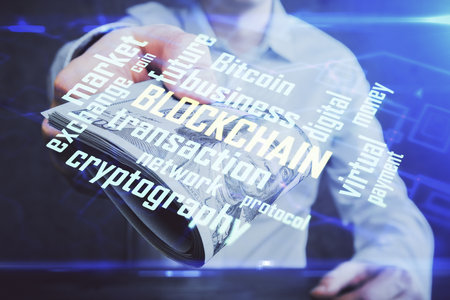 Multi exposure of blockchain theme drawing hologram and USA dollars bills and man hands. Business concept.の写真素材