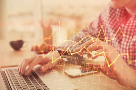 Double exposure of man hands holding a credit card and Forex graph drawing. Stock trading and digital fintech in Internet E-commerce concept.の写真素材