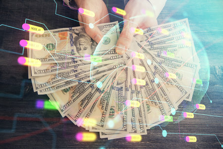 Double exposure of world map drawing hologram and us dollars bills and man hands.の写真素材