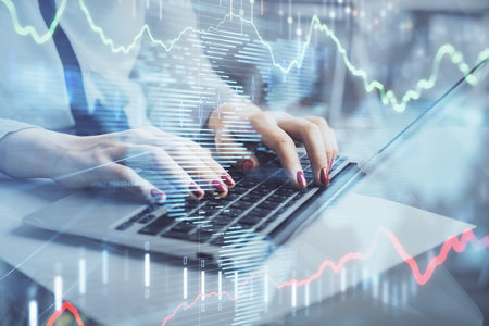 Multi exposure of woman hands typing on computer and financial graph hologram drawing. Stock market...