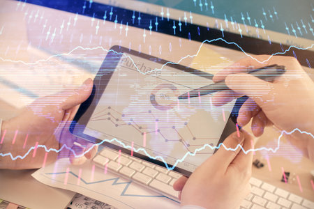 Double exposure of mans hands holding and using a phone and financial chart drawing. Market analysis...