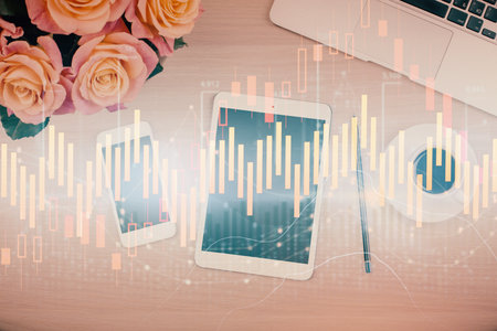Double exposure of forex graph hologram over desktop with phone. Top view. Mobile trade platform concept.の写真素材