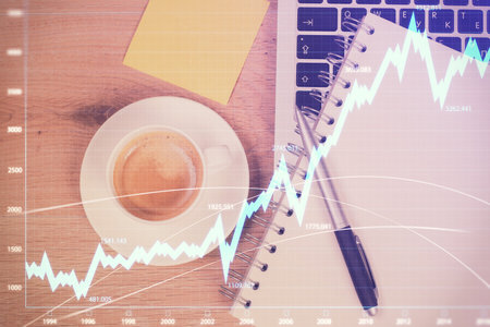 Double exposure of financial chart drawing over table background with computer. Concept of research...