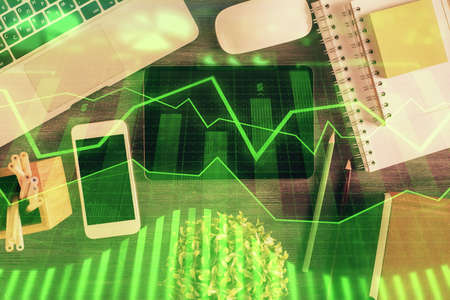 Double exposure of forex chart hologram over desktop with phone. Top view. Mobile trade platform concept.の写真素材