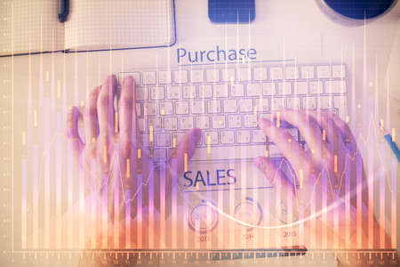 Double exposure of mans hands typing over laptop keyboard and forex chart hologram drawing. Top...