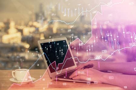 Double exposure of businesswoman hands typing on computer and forex chart hologram drawing....
