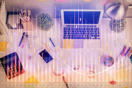 Double exposure of forex chart drawing over table background with computer. Concept of financial research and analysis. Top view.の写真素材