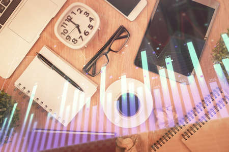 Double exposure of financial chart hologram over desktop with phone. Top view. Mobile trade platform concept.の写真素材