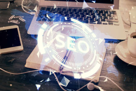 Multi exposure of SEO drawings and desk with open notebook background. Concept of Search optimizationの写真素材