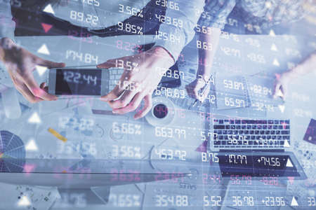 Double exposure of man and woman working together and financial chart hologram drawing. market analysis concept. Computer background. Top View.の写真素材