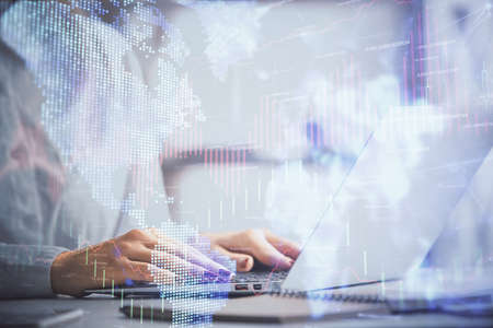 Double exposure of woman hands working on computer and forex graph hologram drawing. Financial analysis concept.の写真素材