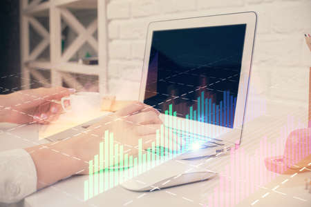 Double exposure of woman hands typing on computer and forex chart hologram drawing. Stock market...