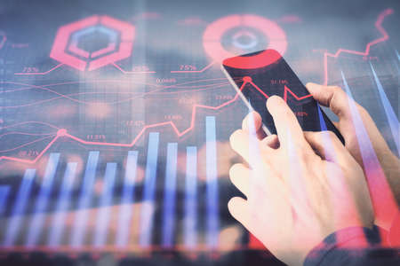 Double exposure of mans hands holding and using a digital device and forex graph drawing. Financial...