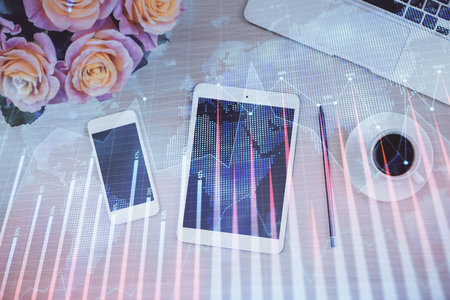 Double exposure of forex graph hologram over desktop with phone. Top view. Mobile trade platform concept.の写真素材