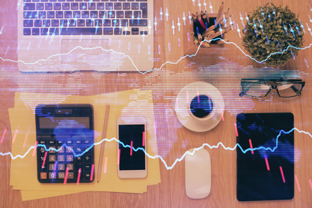 Double exposure of forex chart hologram over desktop with phone. Top view. Mobile trade platform concept.の写真素材