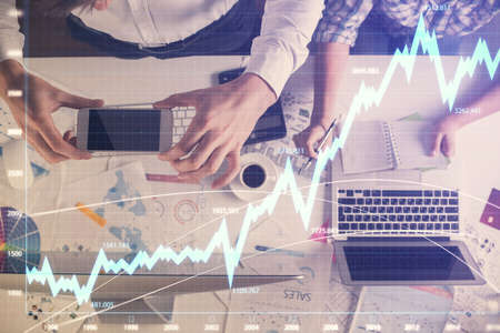 Double exposure of man and woman working together and financial chart hologram drawing. market...