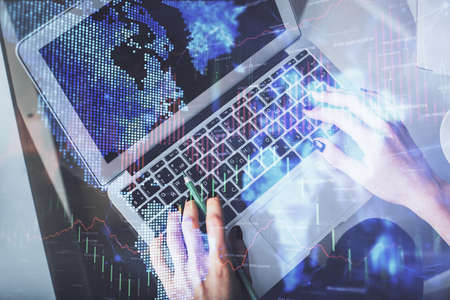 Double exposure of woman hands working on computer and forex chart hologram drawing. Top View....
