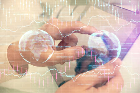 Multi exposure of mans hands holding and using a phone and financial chart drawing. Market analysis...