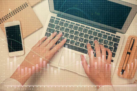 Double exposure of woman hands working on computer and forex graph hologram drawing. Top View....