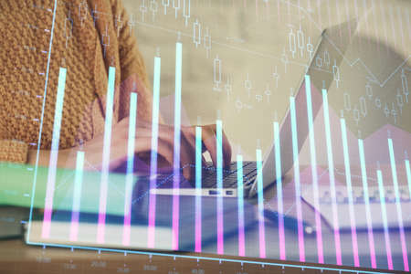 Double exposure of woman hands typing on computer and forex chart hologram drawing. Stock market...