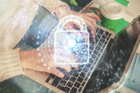Double exposure of woman hands working on computer and lock hologram drawing. Security concept.