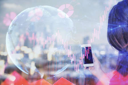 Double exposure of business theme sketch hologram and woman holding and using a mobile device.