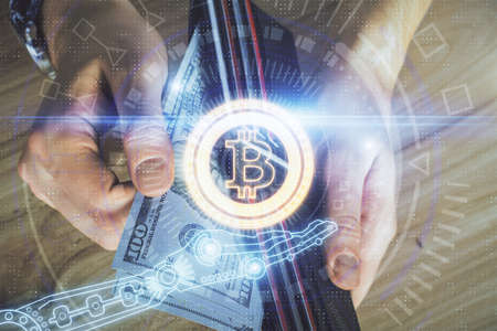 Multi exposure of blockchain theme drawing hologram and USA dollars bills and man hands. Business...