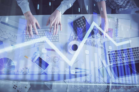 Double exposure of man and woman working together and financial chart hologram drawing. market...