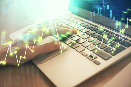 Double exposure of woman hands typing on computer and forex chart hologram drawing. Stock market...