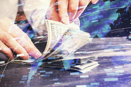 Double exposure of technology drawing hologram and us dollars bills and man hands. Data concept