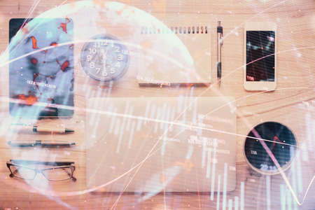 Double exposure of forex graph hologram over desktop with phone. Top view. Mobile trade platform concept.の写真素材
