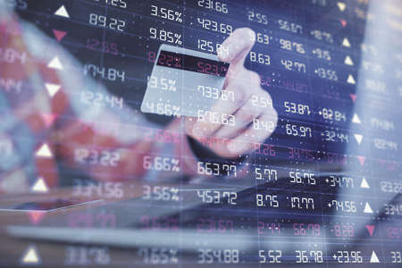 Double exposure of man hands holding a credit card and Forex graph drawing. Stock trading and...