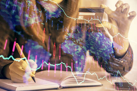 Multi exposure of woman on-line shopping holding a credit card and financial graph drawing. Stock...