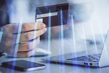 Multi exposure of woman on-line shopping holding a credit card and financial graph drawing. Stock...