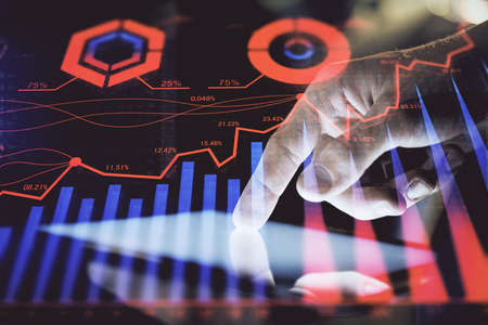 Double exposure of mans hands holding and using a digital device and forex graph drawing. Financial...