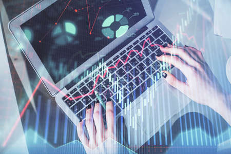 Double exposure of woman hands working on computer and forex chart hologram drawing. Top View....