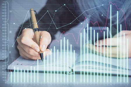 Double exposure of businesswoman hands typing on computer and forex graph hologram drawing. Financial analysis concept.の写真素材