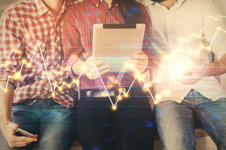 Double exposure of forex graph drawing and man and woman working together holding and using a mobile device. Trade concept.の写真素材