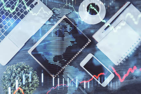 Double exposure of forex chart hologram over desktop with phone. Top view. Mobile trade platform...
