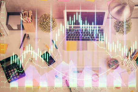 Double exposure of forex chart drawing over table background with computer. Concept of financial...