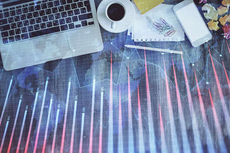 Financial market graph and top view computer on the desktop background. Double exposure. Investment...