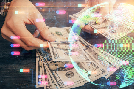 Double exposure of world map drawing hologram and us dollars bills and man hands.の写真素材