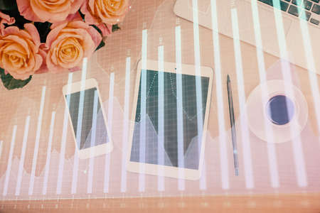 Double exposure of forex graph hologram over desktop with phone. Top view. Mobile trade platform...