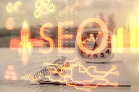 Multi exposure of SEO drawings and desk with open notebook background. Concept of Search...
