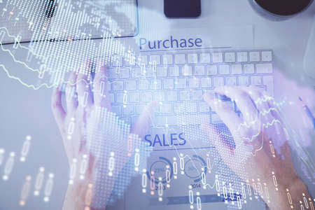 Double exposure of mans hands typing over laptop keyboard and forex chart hologram drawing. Top view. Financial markets concept.の写真素材
