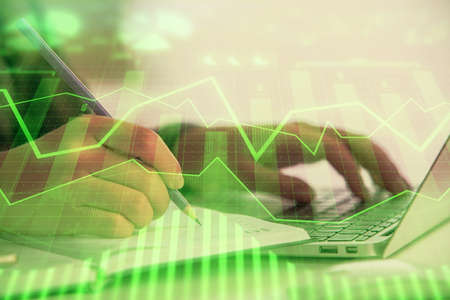 Double exposure of businesswoman hands typing on computer and forex chart hologram drawing....