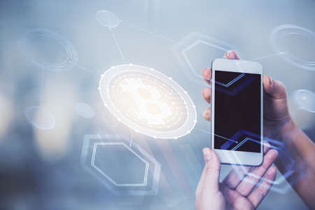 Double exposure of blockchain business sketch hologram and woman holding and using a mobile device.