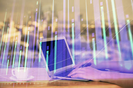Double exposure of businesswoman hands typing on computer and forex chart hologram drawing....